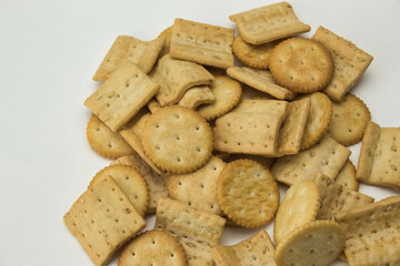 top view of salty square and round shaped cookies on white background