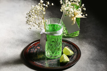 Glasses with tasty cocktail and beautiful gypsophila flowers on dark background