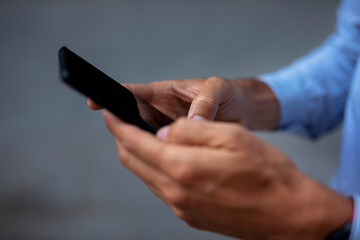 Close up of businessman using the phone. Young manager typing a message