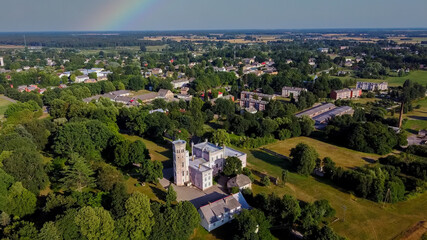 Vecauce Manor in Latvia Aerial View of the Pink Castle Through the Park. Vecauce Castle Tower With a Flying Latvian Flag. View From Above.