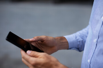 Close up of businessman using the phone. Young manager typing a message