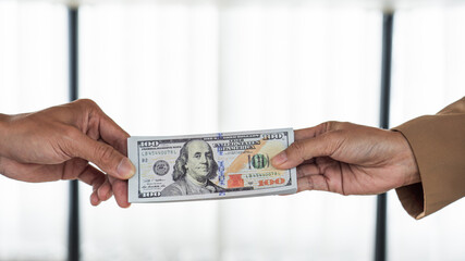 two hands passing bills making agreement to initiate the new business