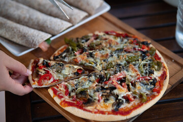 Delicious pizza on a wood table with fajitas