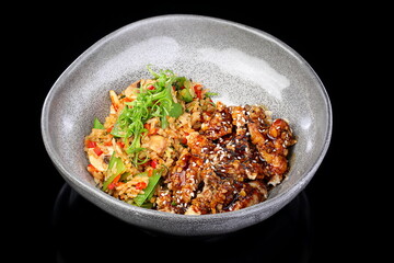 Meat with rice and vegetables on black background
