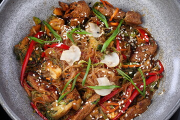 Meat with vegetables, sesame seeds and pasta