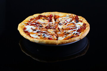 Pizza with mushrooms, sausage and olives on a wooden background