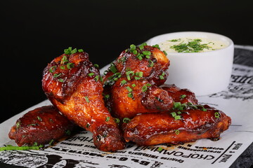 Chicken legs in teriyaki sauce on black background