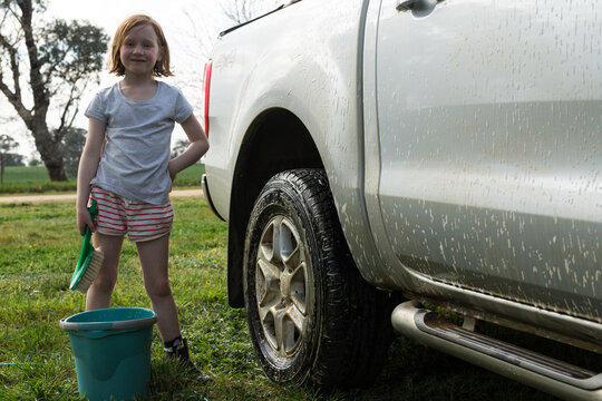 Young girl washing a car for pocket money