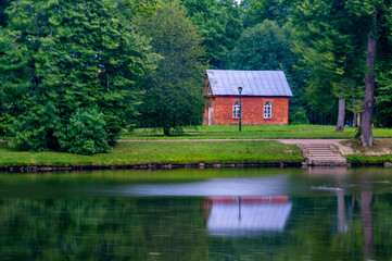 Fototapeta na wymiar red brick house on the shore of a pond.