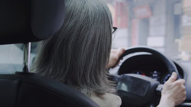Nervous senior woman sitting in car drumming fingers, cant leaving parking lot