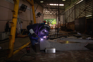 Skillful welders weld steel in the factory. Construction site metal welder. builder wear fireproof...