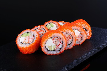 Rolls with red caviar on a black background
