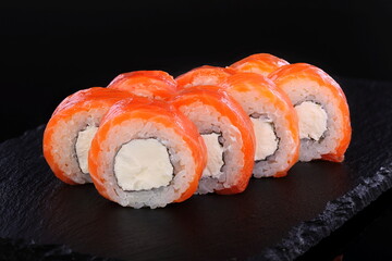 Rolls with red caviar on a black background