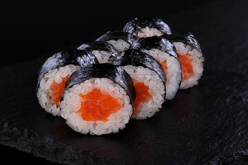 Rolls with red caviar on a black background