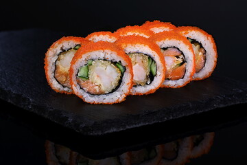 Rolls with red caviar on a black background