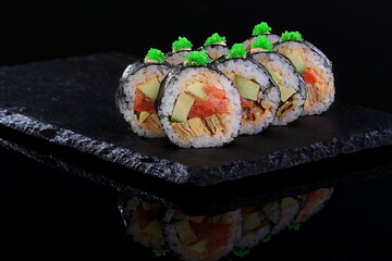 Rolls with red caviar on a black background