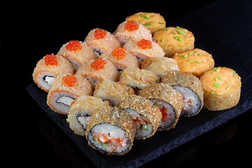 Rolls with red caviar on a black background