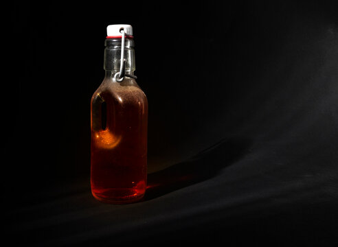 Glass bottle closed with a metal cap with an amber liquid inside