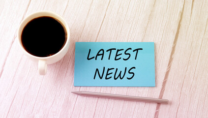 LATEST NEWS text on the blue sticker with cofee and pen