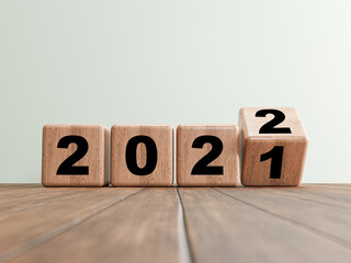 Flipping wooden cube block for change 2021 to 2022 on wooden floor for preparation merry Christmas...