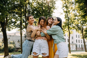 Naklejka premium Group of young women outdoors, having good time, hugging and smiling.