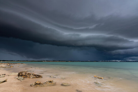 A dark shelf cloud approaches over the ocean