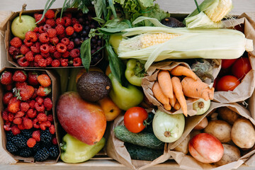 Closeup of box full of various organic vegetables, fruits and berries. Food delivery concept.