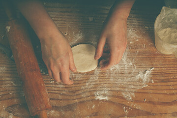 Young woman making homemade dumplings on wooden desk. Dumplings with potatoes and cheese stuffing. National food, eating, delishion, diet concept.