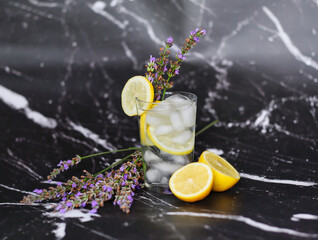 Lavender Lemonade with Citrus and Ice Cubes Isolated on Black Marble Background. Refreshing...