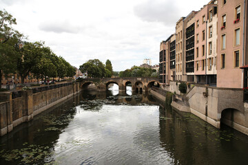 Naklejka premium Metz, France. Buildings on the banks of the Moselle river and the old bridge