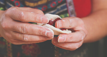 Cherry dumpling. Young woman making homemade dumplings. National food, eating, delishion, diet concept. Horizontal image.