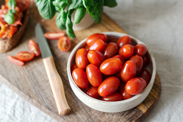 Bowl of cherry tomatoes on a cutting board.