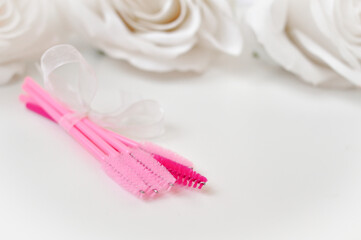 colored brushes for lash extensions in beauty salon,materials for lashmaker on white background, copy space