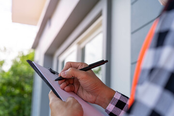 ..Inspector or engineer is checking and inspecting the building or house by using checklist....