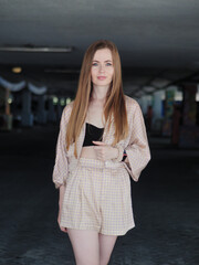 Fototapeta na wymiar Young beauty blonde woman with gorgeous long hair enjoying free lazy time in a mall parking