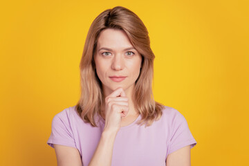 Portrait of intelligent lady look camera finger chin think planning strategy on yellow background