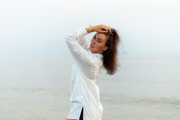Young pretty fashion girl in white shirt. vacation at sea.Romantic Young Woman on Blue Natural summer Background.