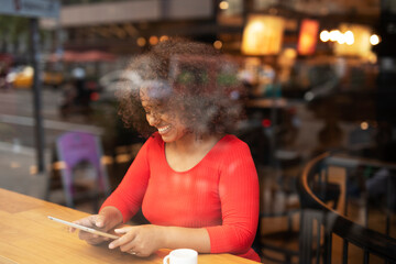Businesswoman using tablet in cafe. Beautiful woman sitting in cafe, reading the news online
