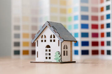 a beautiful small model of a house on a green background, a house in miniature for an architectural project or a design site, a designer or an architect develops the design of a residential house on