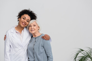 Cheerful african american doctor hugging senior patient