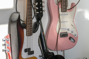 Old battered guitars hanging on a music room wall.