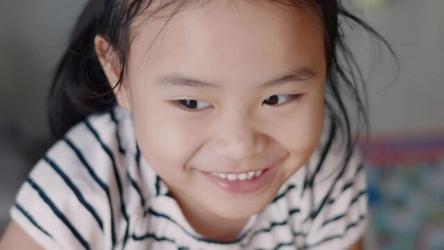 Asian girls are laughing. The child's face was smiling happily. Hand-held 4k slow-motion footage