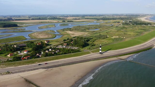 Aerial seaside approach to the lighthouse situated onshore with the panorama of Waterdunes - a nature area and recreational park in the province of Zeeland, The Netherlands