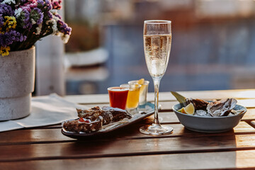 Fresh open oysters with a glass of chilled prosecco wine and set of shoot alcoholic cocktails served on table. Seafood delicios