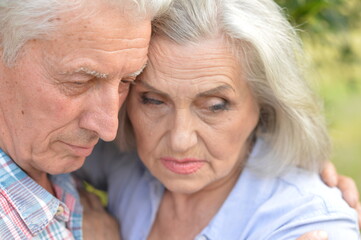 Portrait of sad senior couple in the park