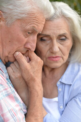 Portrait of sad senior couple in the park
