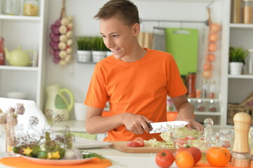 young man cooking vegetables in kitchen