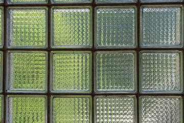 transparent square glass bricks are laid in the form of a wall.