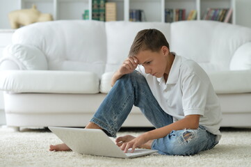 Fototapeta premium boy using modern laptop at home