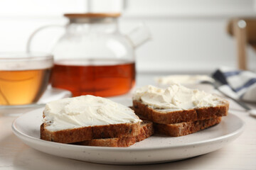 Bread with cream cheese on white wooden table